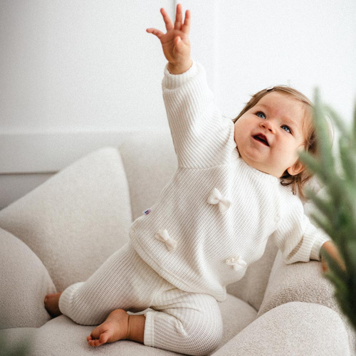 Fluffy Tails Sweterek dla dziewczynki Eevi– ecru, z kokardkami i ściągaczami